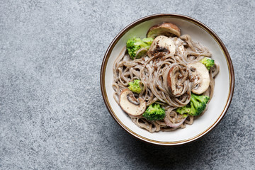 Soba noodles with mushrooms and broccoli and creamy sauce. Stir fried wok dishes Asian cuisine