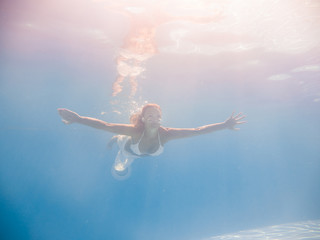 Obraz na płótnie Canvas Woman underwater at the pool