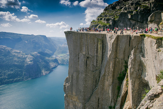 Preikestolen, Norge. Tourists on a stone plateau hanging over the fjord.   tourist in the mountains of Norway. Pulpit Rock