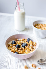 Homemade fitness granola with yoghurt and berries on white kitchen background