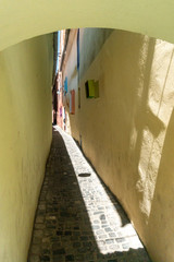 "Strada Sforii" - colorful Rope Street in Brasov city, Transylvania, Romania, one of the narrowest streets in Europe