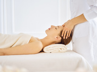 Obraz na płótnie Canvas Beautiful woman enjoying facial massage with closed eyes