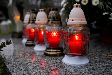 A lit candle on a grave