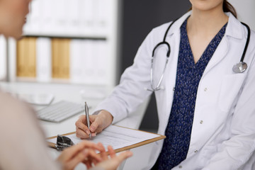 Doctor and patient discussing current health examination while sitting in clinic. Perfect medical...