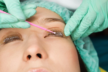 Eyelash care treatment procedures. Staining, curling, laminating for lashes. Beauty model with...