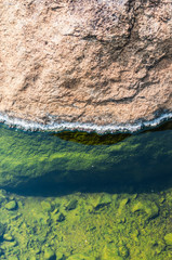 green on stone of hot spring pond closeup