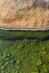 green on stone of hot spring pond closeup