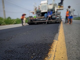 Road maintenance work with the ASPHALT HOT MIX IN  - PLACE RECYCLING (picture blurred)