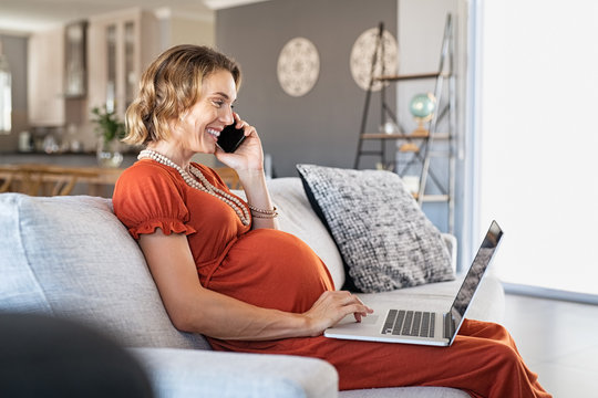 Pregnant woman working from home with laptop