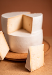 cheese wheel, sliced in triangular portions, made from goat's, cow's milk, many large pieces of cheese, triangle, industrial sizes