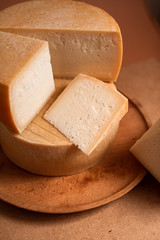 cheese wheel, sliced in triangular portions, made from goat's, cow's milk, many large pieces of cheese, triangle, industrial sizes
