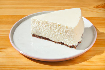 classic cheesecake on white plate on  wooden table