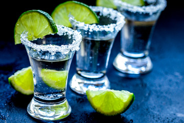 Alcohol shots with lime and salt on black background