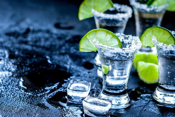 Alcohol party with tequila, ice and salt on black background