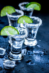 Alcohol party with tequila, ice and salt on black background
