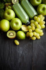 Mixed green fruits and vegetables placed on black wooden table
