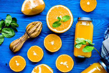 Orange juice in bottle with slices and mint on table top view