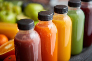 Colorful bottles filled with fresh fruit and vegetable juice or smoothie
