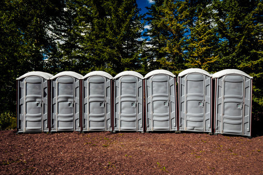 Outhouses in a row, outdoors.