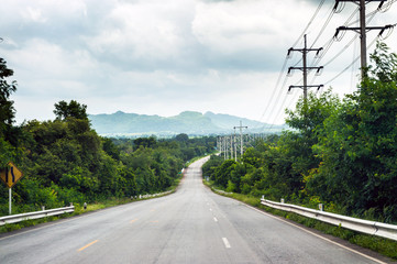 road on mountain with clouds sky