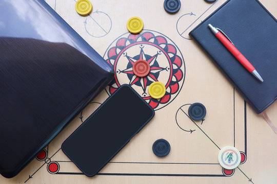 Laptop and smartphone isolated on carom board.  Work from home and pass time concept 