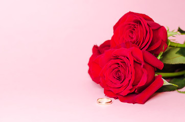 wedding ring and red rose flower on pink background, copy space. card, postcard, text