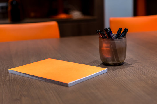 Bloc note et pot &agrave; crayons dans une salle de r&eacute;union