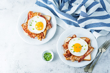 Fried egg fried bacon sandwiches on a light background