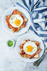 Fried egg fried bacon sandwiches on a light background