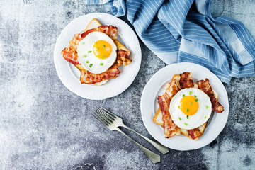 Fried egg fried bacon sandwiches on a light background