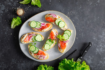 Sandwiches with homemade ciabatta bread, salted salmon fish, feta cheese, cucumber, onion and fresh lettuce salad