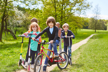 Fototapeta na wymiar Children with bike and scooter on a trip