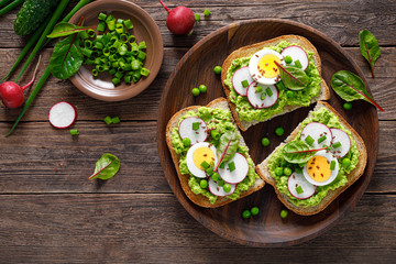 Sandwiches with wholemeal bread, hummus or puree of fresh green peas, radish, cucumber, boiled egg, green onion and chard