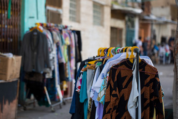Colorful second hand clothes at the market in Israel. Selective focus.
