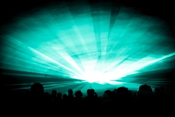 Turquoise laser show nightlife club stage at party people crowd. Luxury entertainment with audience silhouettes in nightclub event, festival or New Years Eve. Beams and rays shining colorful lights