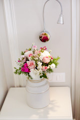 A beautiful bouquet of delicate flowers stands on the bedside table in the bedroom