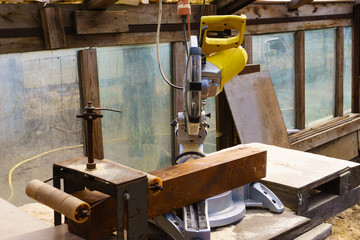 Miter saw in sawdust stands on a workbench after work.