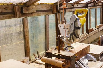 Miter saw in sawdust stands on a workbench after work.