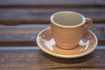 Colorful ceramic cup on wooden table for espresso