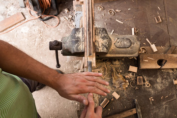 Male carpenter working on old wood in a retro vintage workshop.