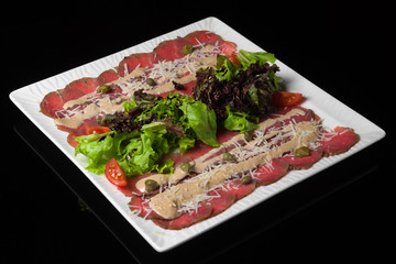 Meat slices with tomatoes salad with Basil sauce grated cheese