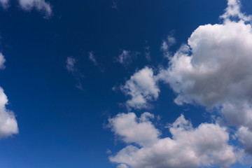 White fluffy clouds floating in the blue summer sky. Cloudy serene landscape.