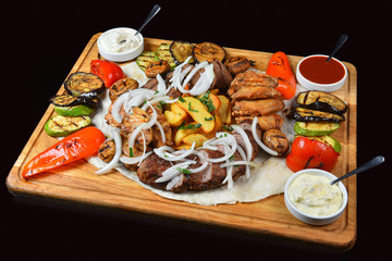 Assorted grilled meat and vegetables in a rustic style, sauce,