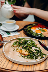 Salad with sorrel tortilla and walnuts, Parmesan, on a beige plate