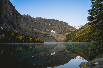 Obraz premium still lake in a mountain valley on a fall day