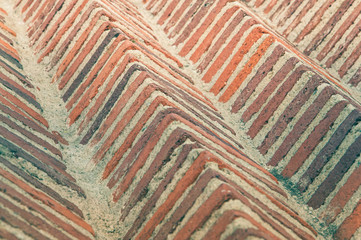 Rustic bricks of reddish colors in rows of pyramidal shape.