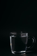 Glass with water on a black background. Cup of water.