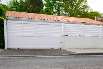 Fototapeta na wymiar white portal suburb metal modern gate white fence on home suburb street access door house garden
