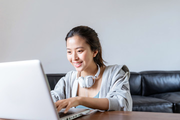 A young Asian woman in a sports office at home