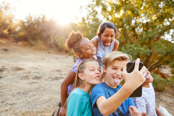 Naklejka premium Group Of Multi-Cultural Children Posing For Selfie With Friends In Countryside Together